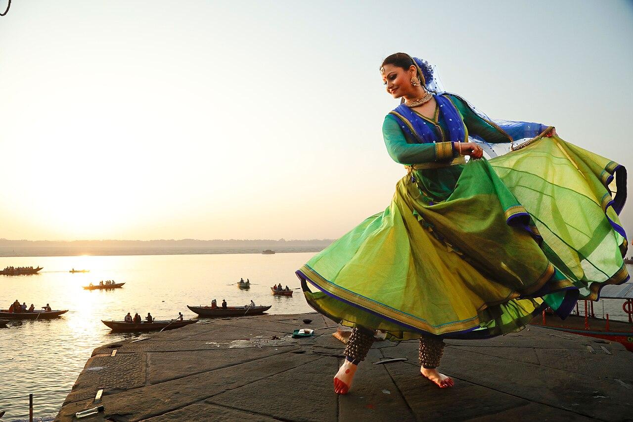 Kathak dancer mid-spin in a flowing green costume