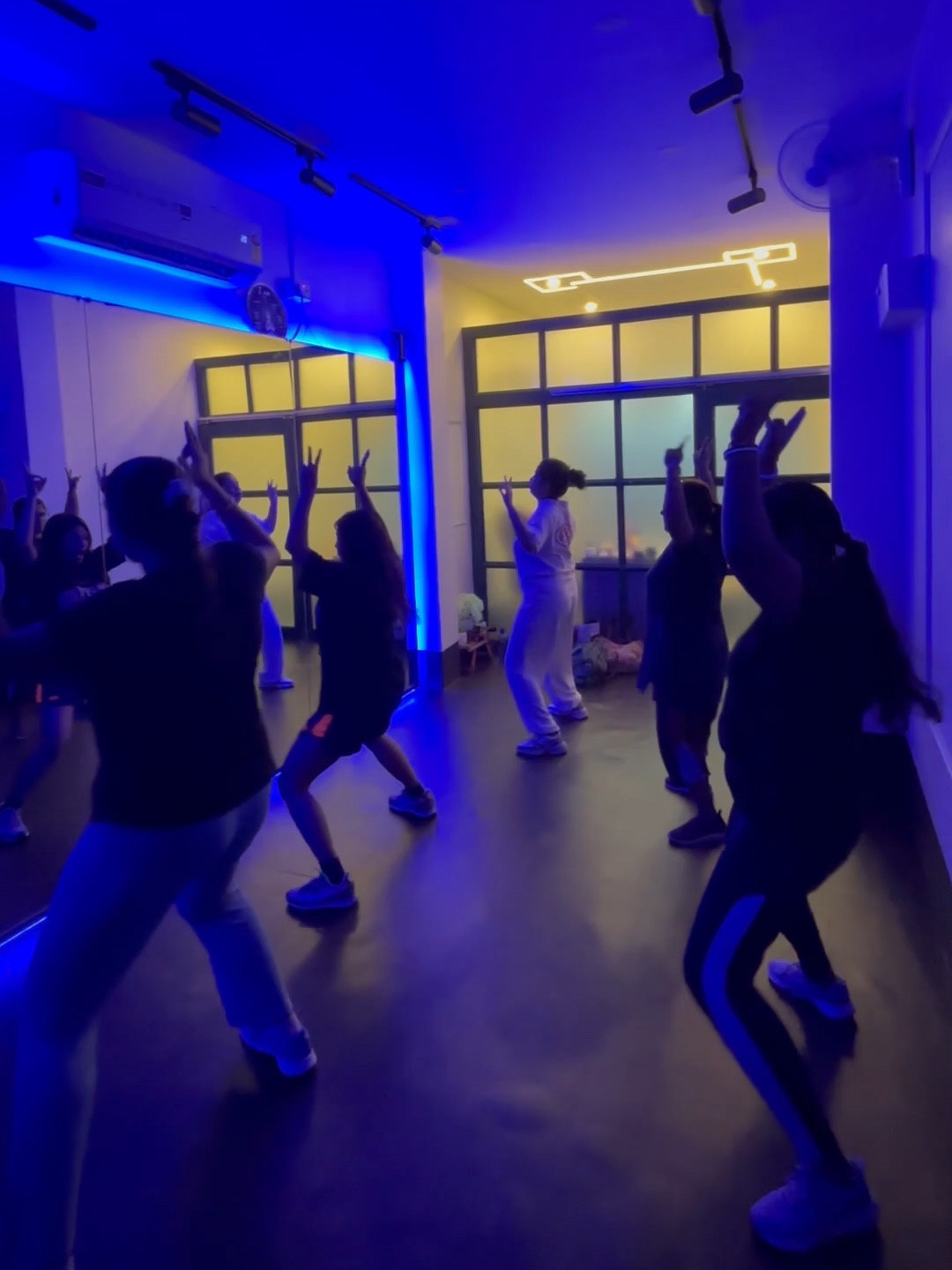 Zumba class dancing towards the warm light of the studio windows at Netra
