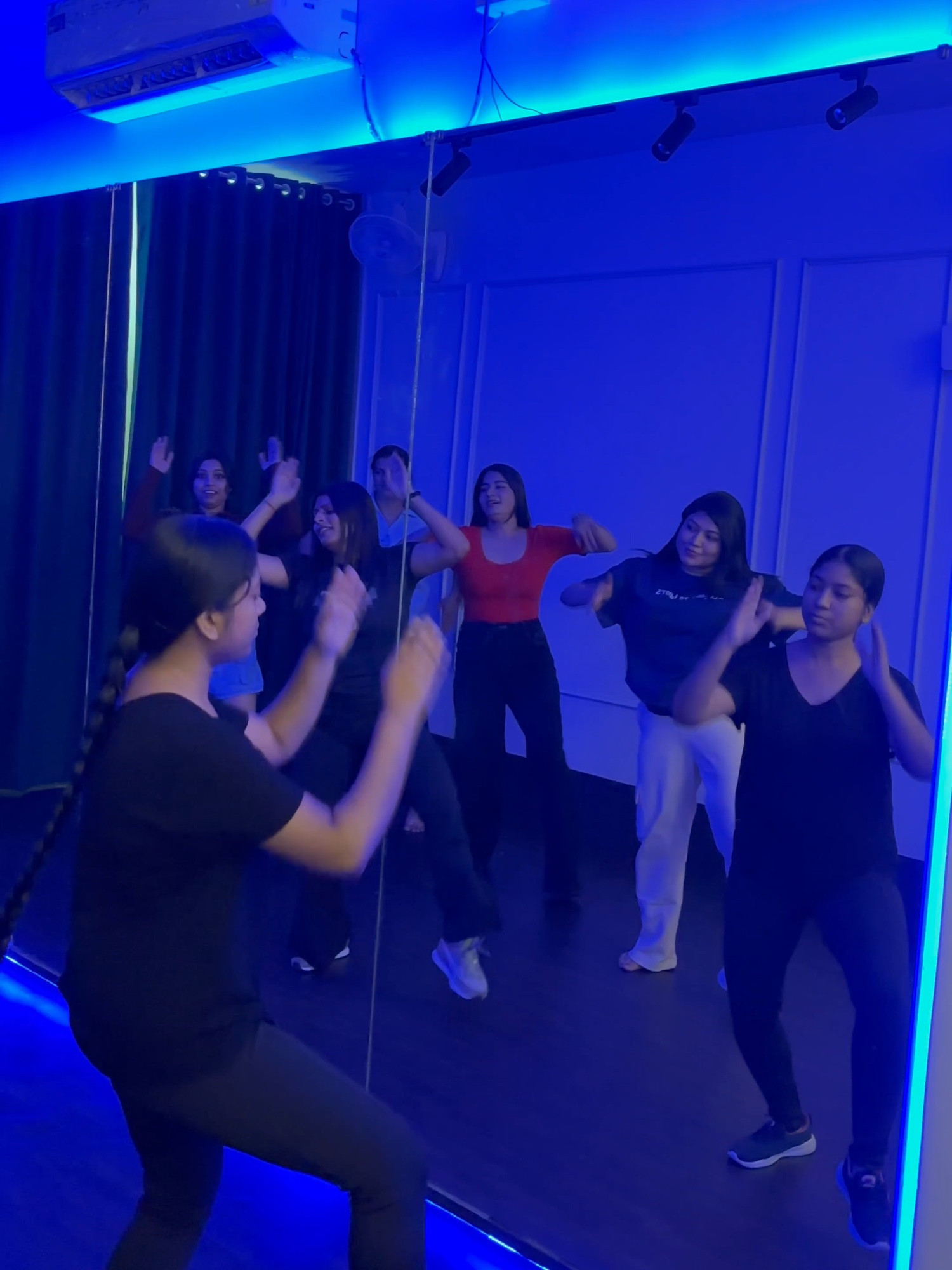 Zumba instructor leading the class in front of the studio mirror at Netra